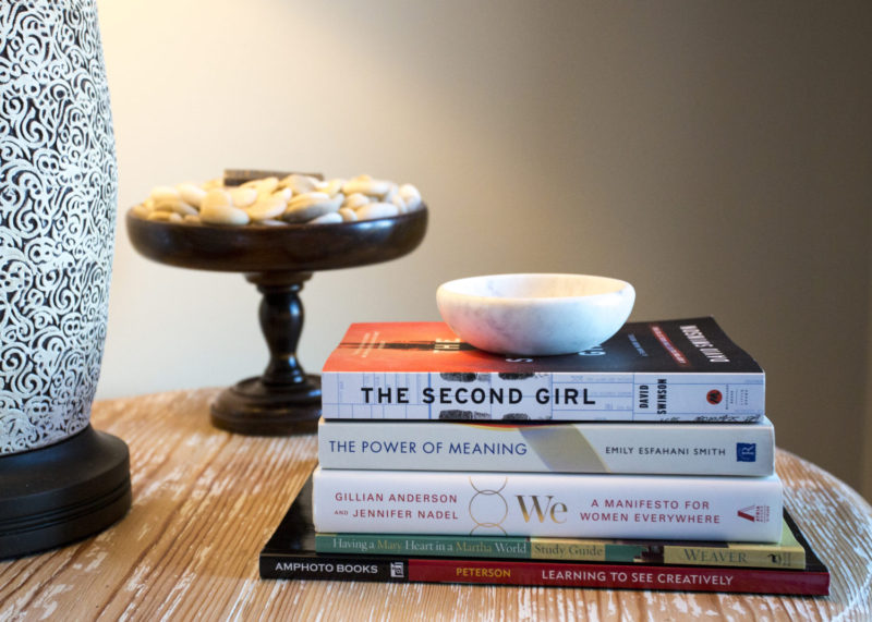 Showing a stack of books on a nightstand.